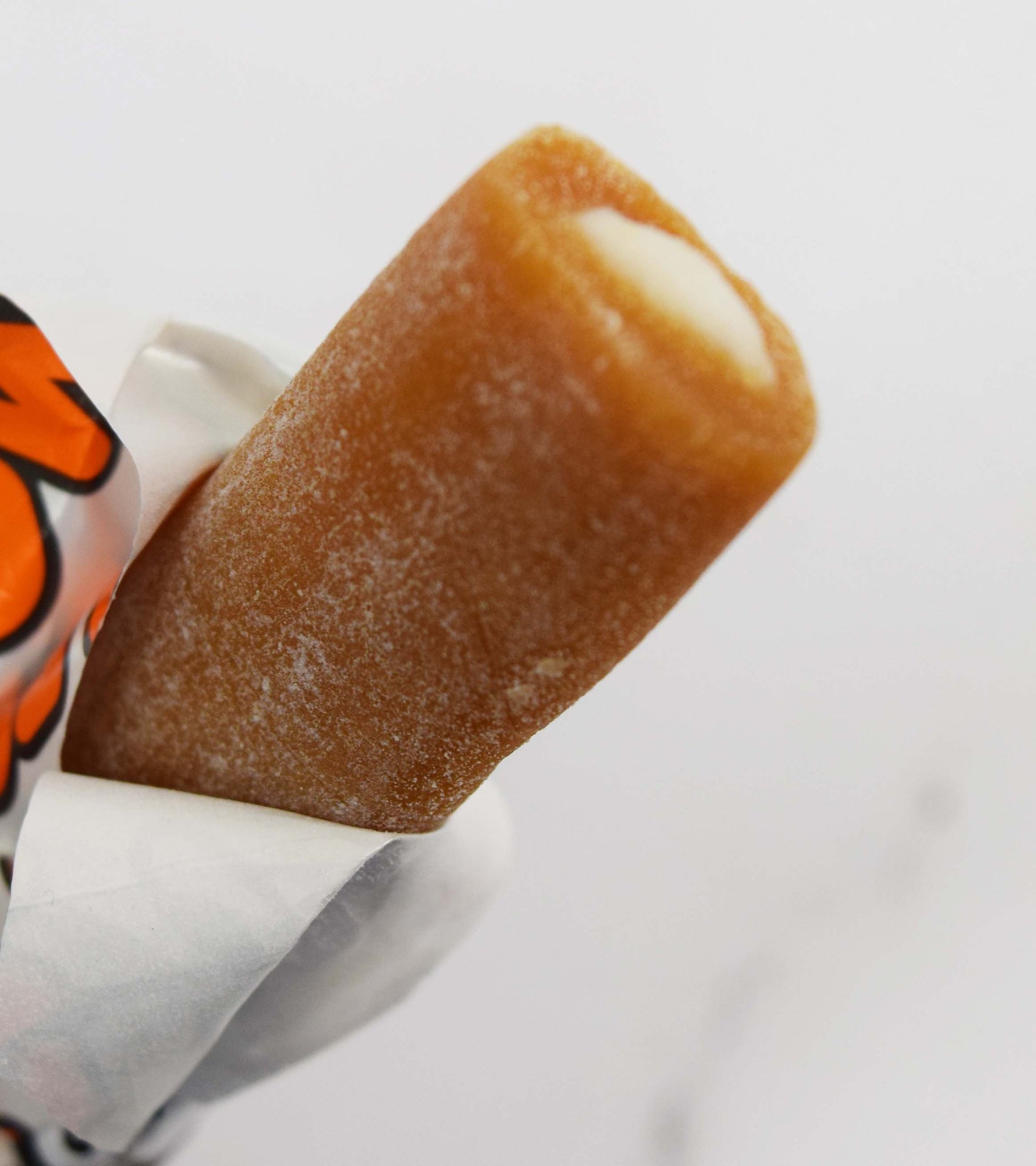 Close-up of a Mini Cow Tales bar with Caramel outside and Cream inside with a white background