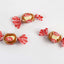 Three wrapped Goetze's Caramel Creams candies with red and white wrappers on a white background